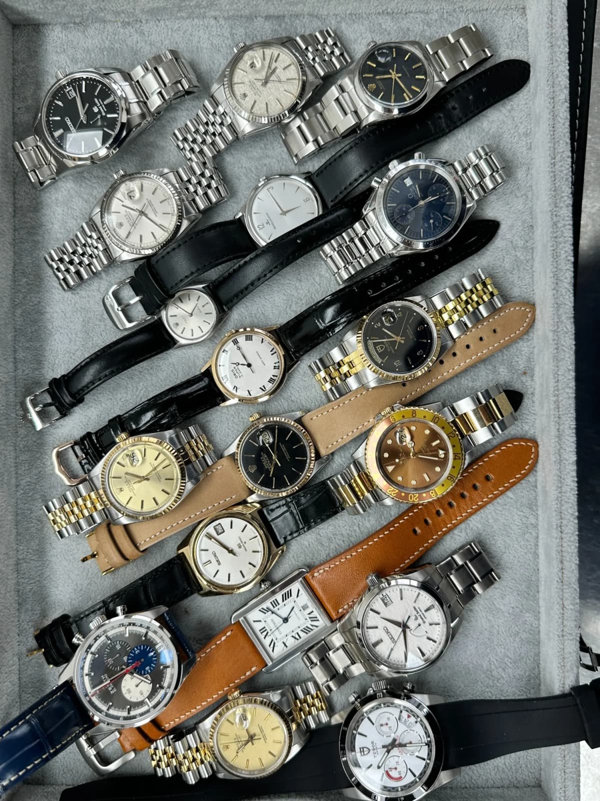 Pre-owned watches laid out in a tray